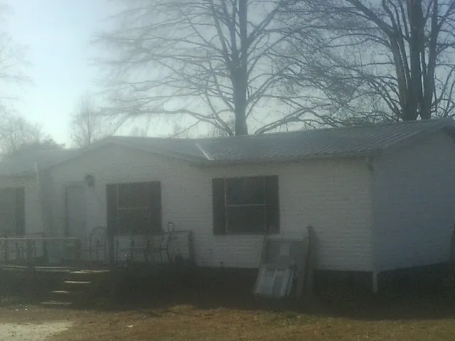 New metal roof on a white painted brick home on a foggy morning in Weston